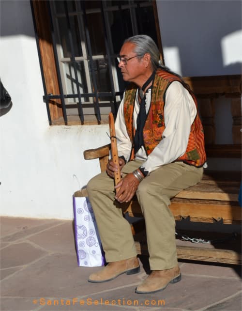 Philip Mangas Haozous watching the singers before he performs the Native flute songs he learned from his father.