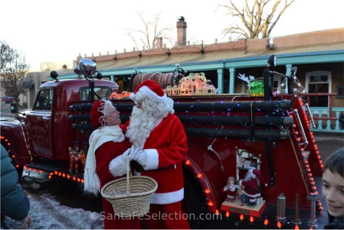 Mr & Mrs Claus beside the vintage fire truck.