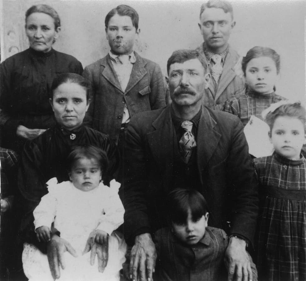Young Ross Salazar with family. Ross is under the hands of his father.